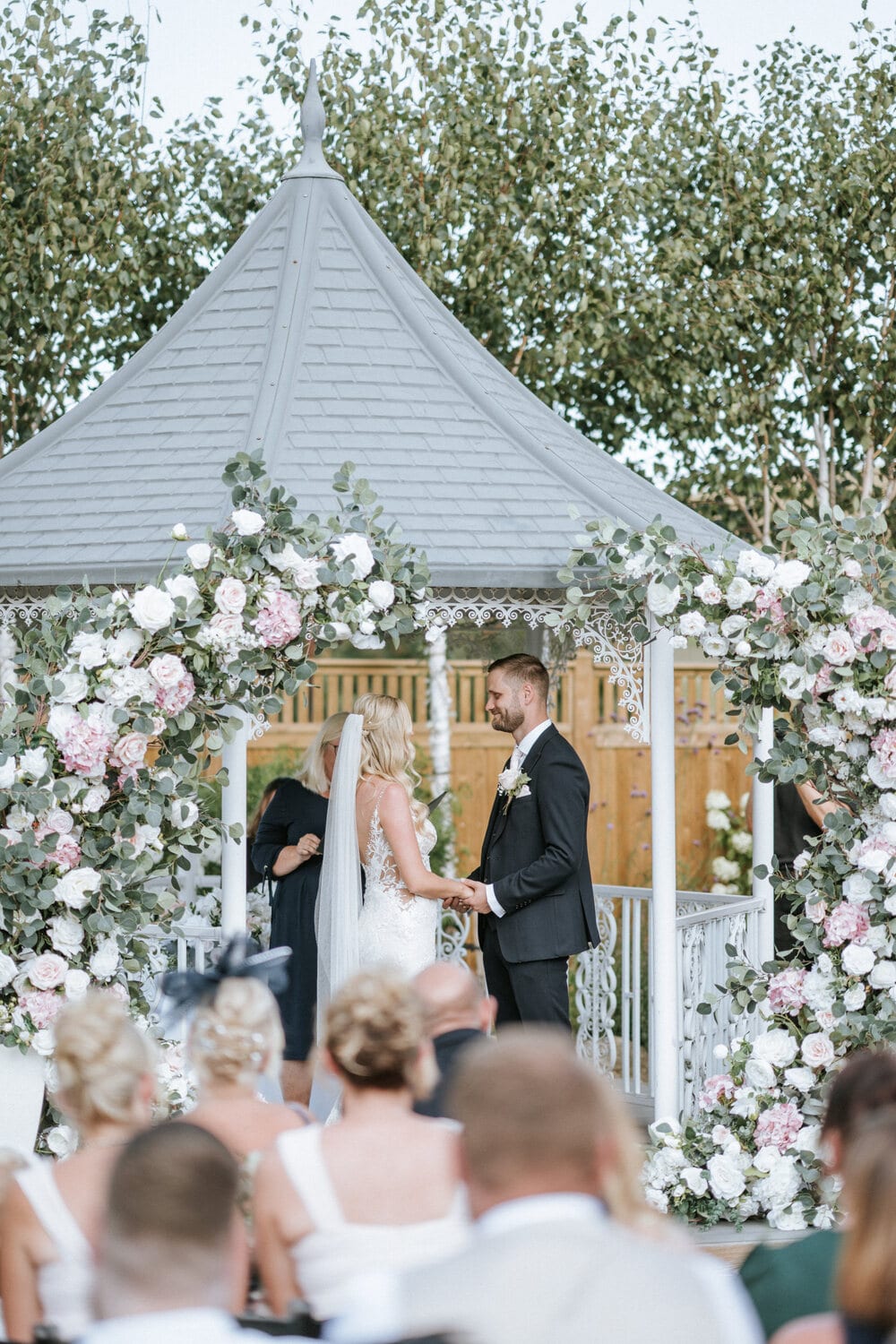 A couple exchanging vows at the lavender walk gazebo