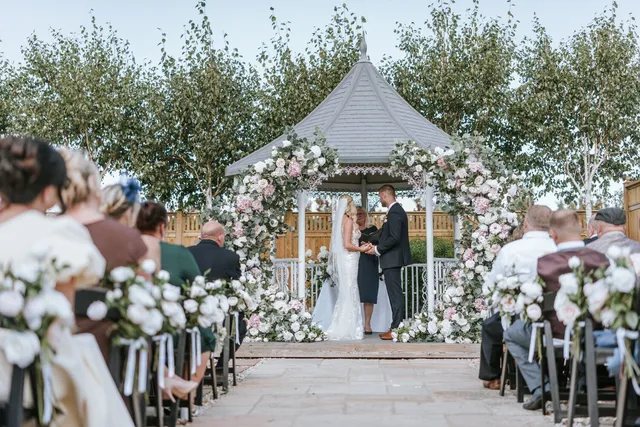 The gazebo framed by pink and white florals