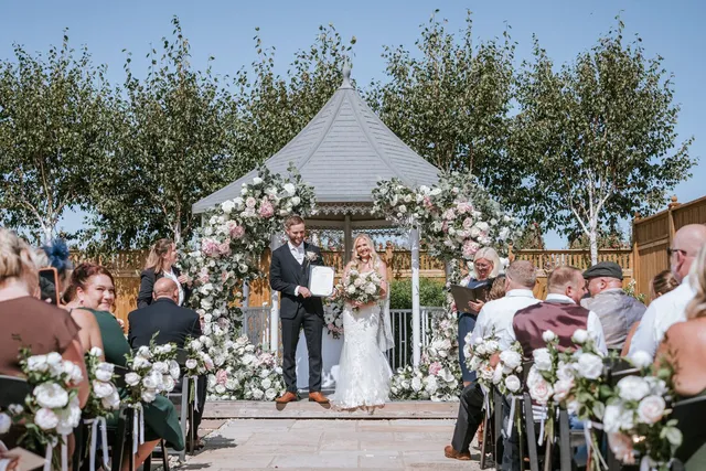 The gazebo dressed with blush and white blooms