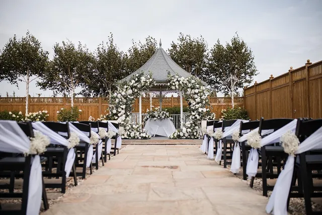 An aisle dressed with black chairs and white sashes