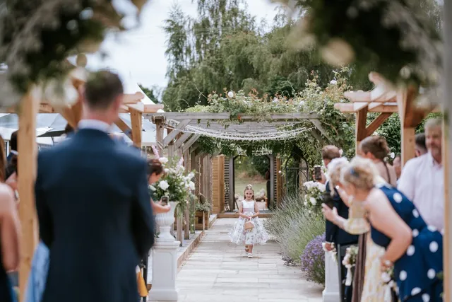 A flower girl leading the way down the aisle
