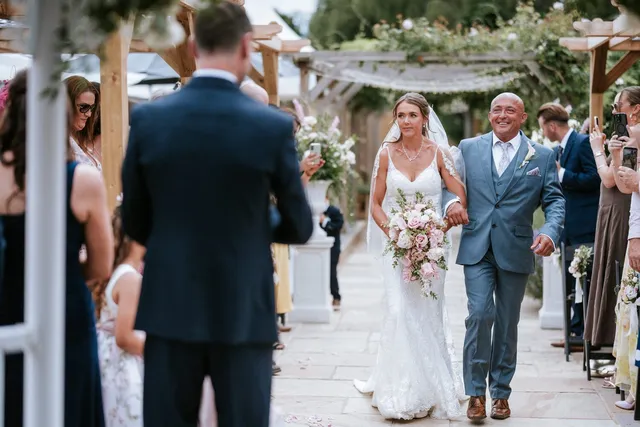 A bride and her father reaching the ceremony