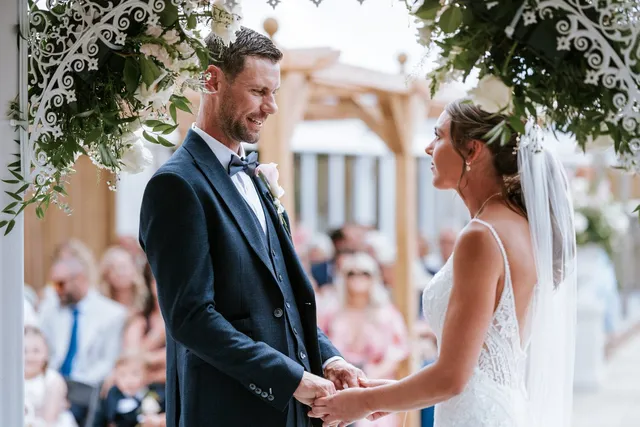 A couple holding hands as they say their vows