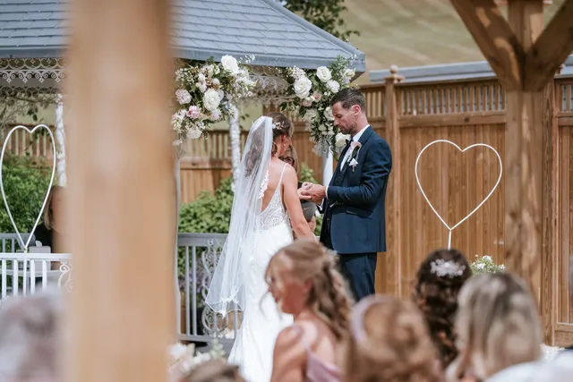 A couple exchanging rings in front of their guests