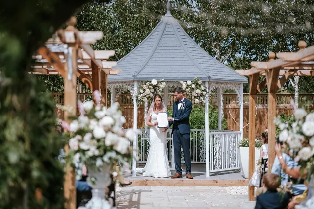 A ceremony at the gazebo with white floral urns