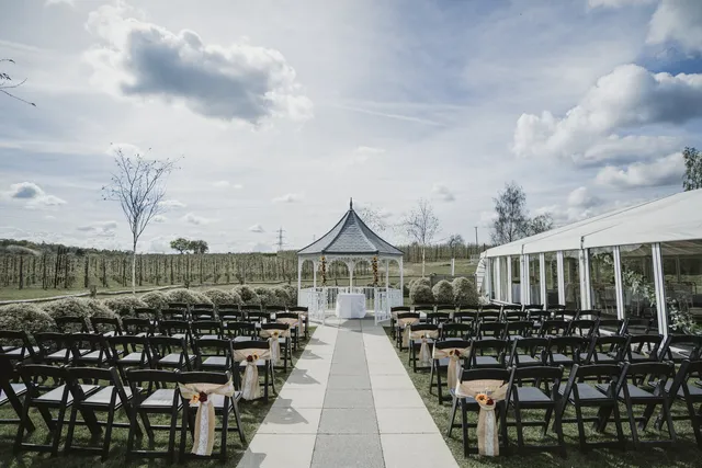 The white gazebo set for a ceremony in the Orchard Garden, chairs either side of the aisle