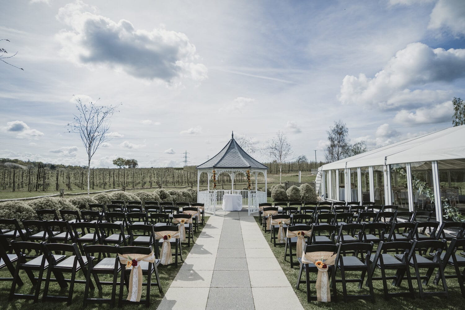 Rows of chairs and the gazebo set for a ceremony in the Orchard Garden