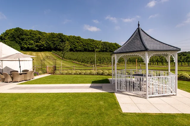 The Orchard Garden gazebo on the lawn with the orchards beyond