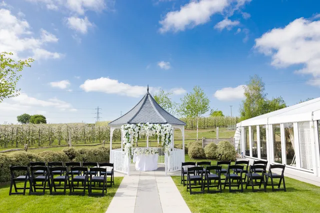 The Orchard Garden gazebo dressed with white florals under a blue sky