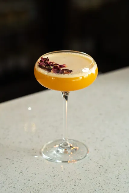 A coupe cocktail finished with dried rose petals