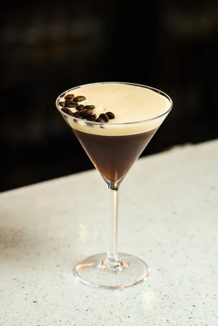 An espresso martini topped with three coffee beans
