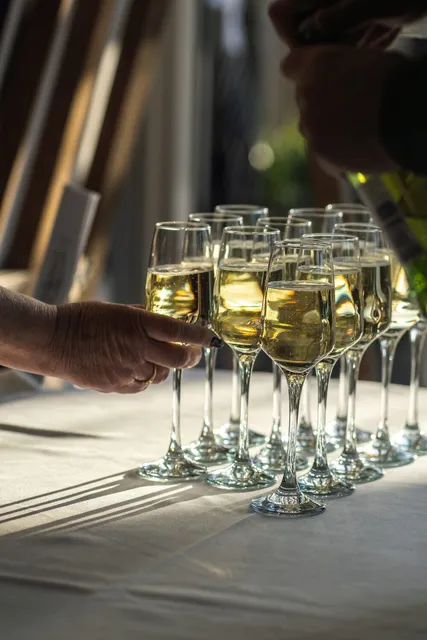 A tray of chilled champagne being handed to arriving guests