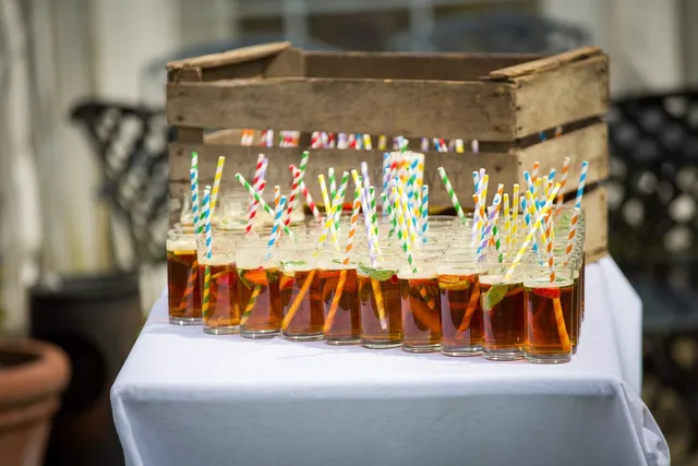 Jars of Pimms with paper straws in a wooden crate