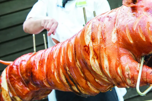 A hog roast turning on the spit