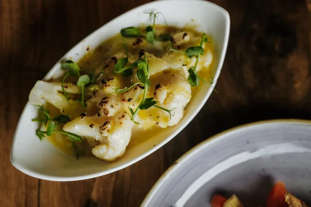 A fish dish in a creamy sauce with micro herbs