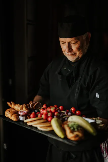 A chef plating a breakfast spread