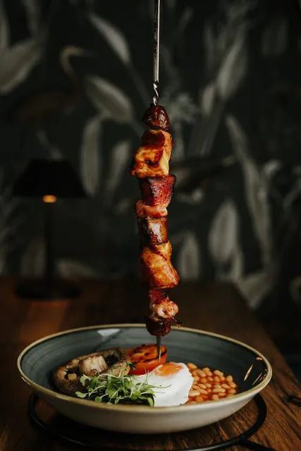 A skewer suspended above a bowl