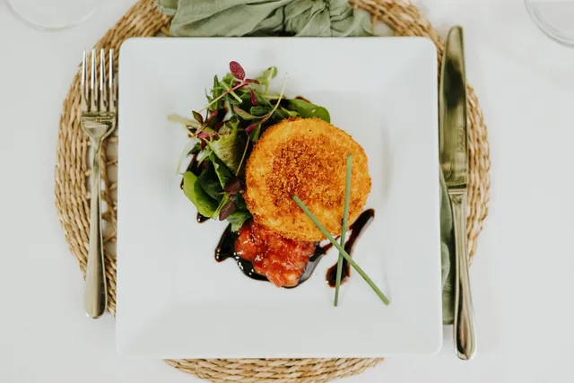 A fishcake on dressed leaves