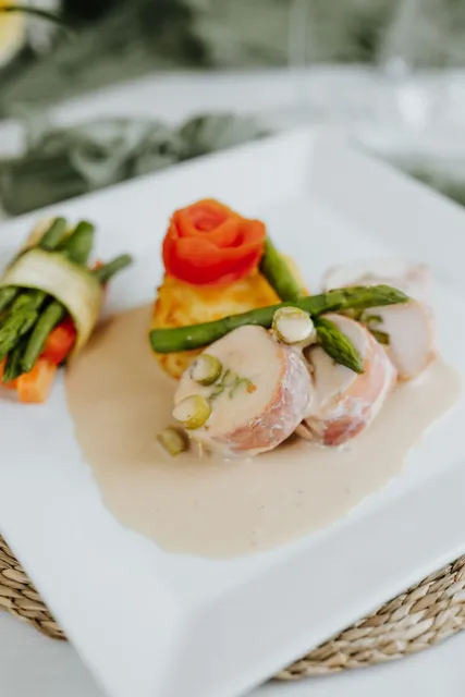 A chicken main with asparagus and tomato rose