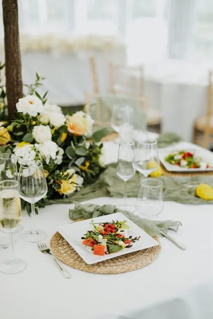 A wedding breakfast table dressed with yellow florals