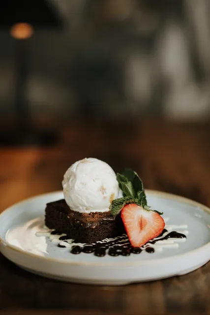A brownie with ice cream and strawberries