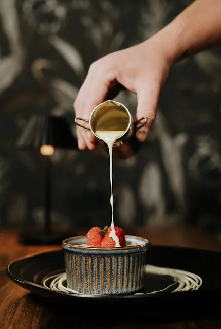 Sauce being poured over a warm dessert