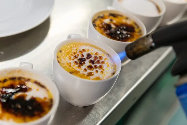 Creme brulee being caramelised with a blowtorch
