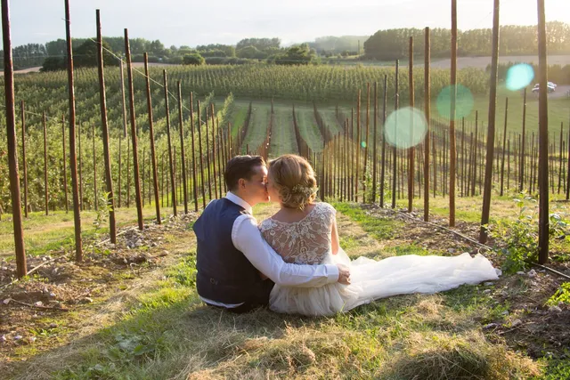 A couple sitting together in the orchard grass