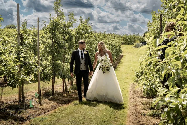 A couple walking a grass path between the trees