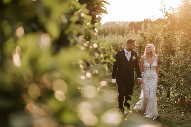 A couple walking through the autumn orchard