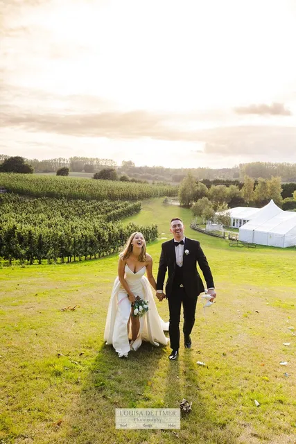 A couple walking the field path with the marquee behind