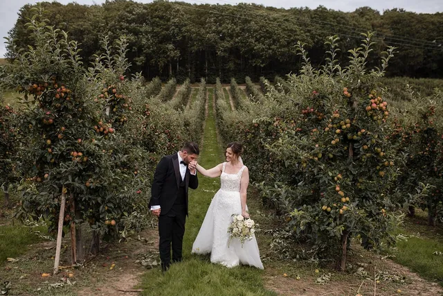 A couple walking the orchard in early autumn