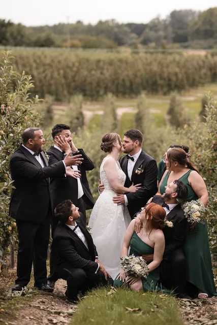 A wedding party celebrating in the orchard