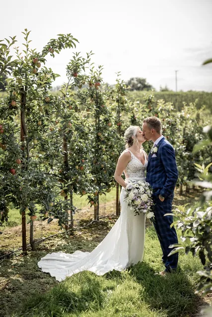A couple kissing among the apple trees