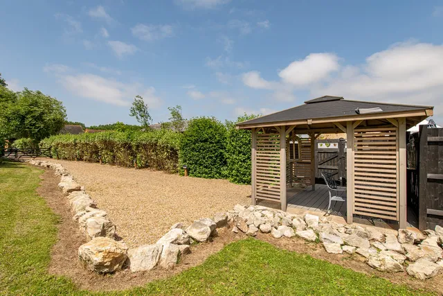 The wooden shelter at the edge of the orchard