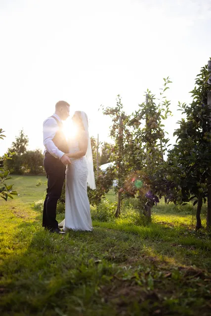 A couple with the sun setting between them