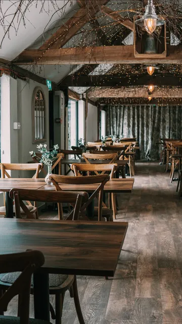 Tables and chairs at The Roost with the curtained end wall