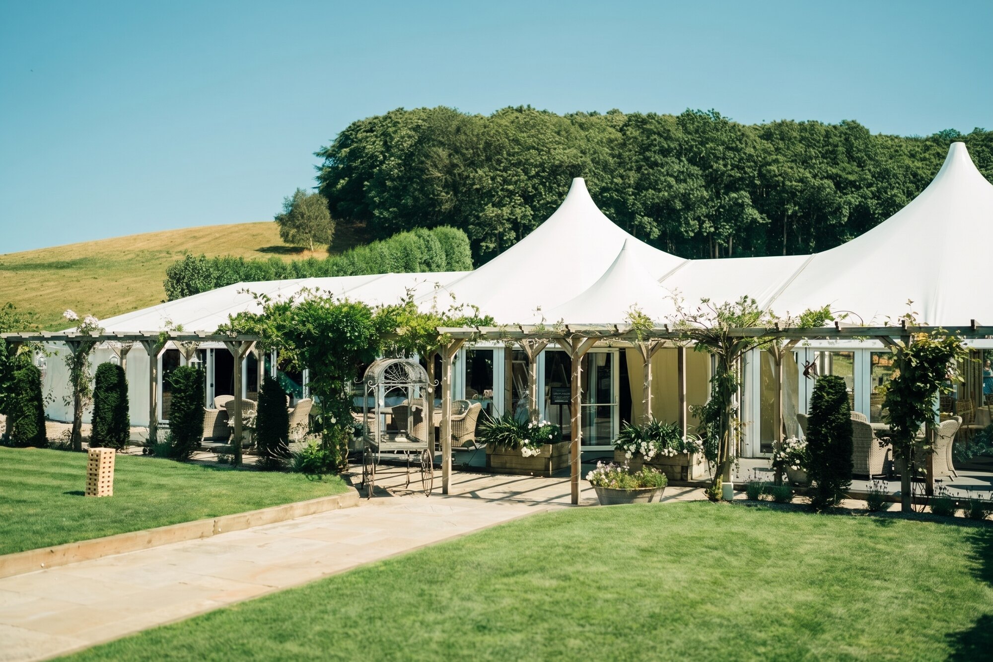 The white pavilion, pergola and gardens at The BarnYard on a summer day