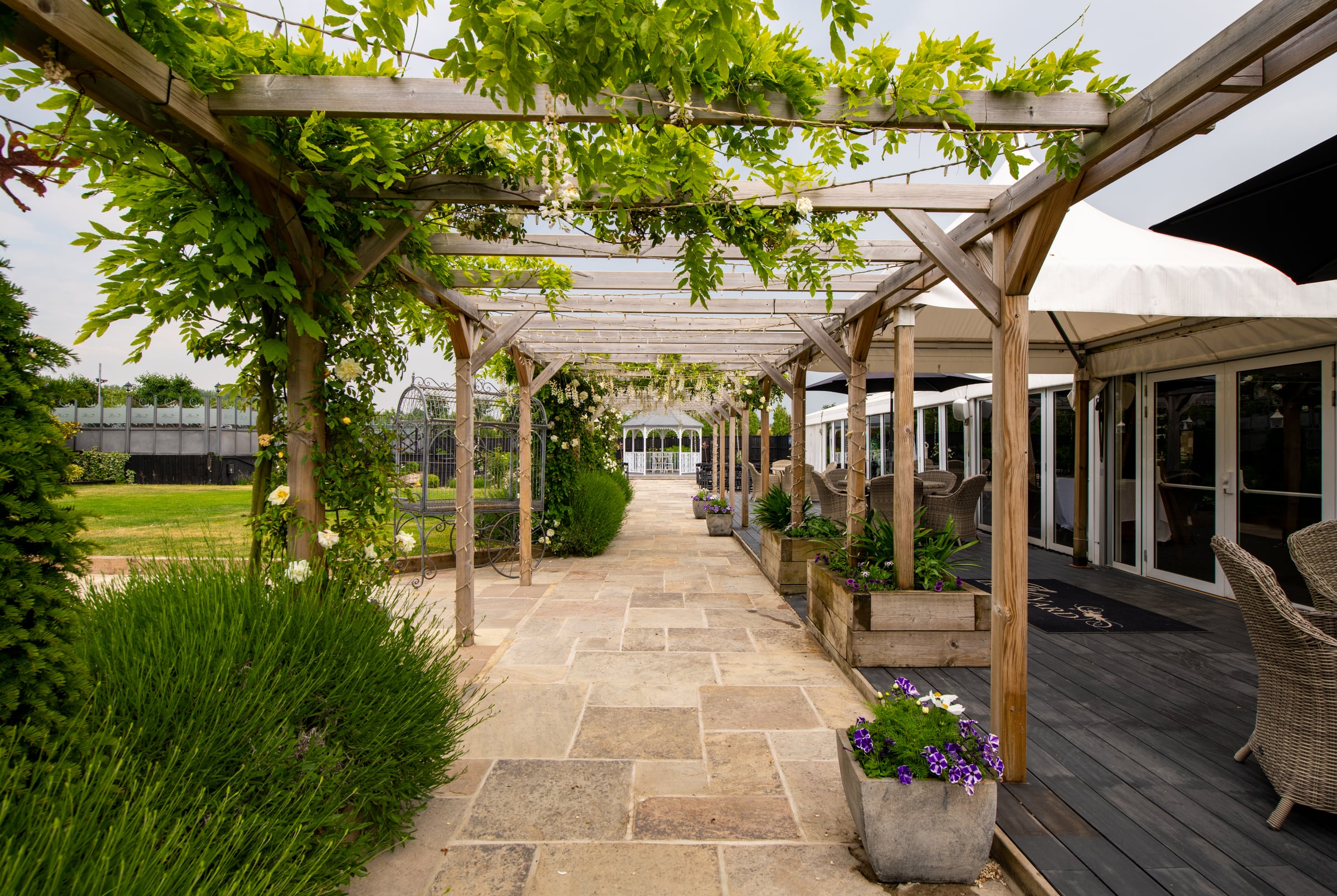The wisteria-covered walkway leading to the ceremony area at The BarnYard