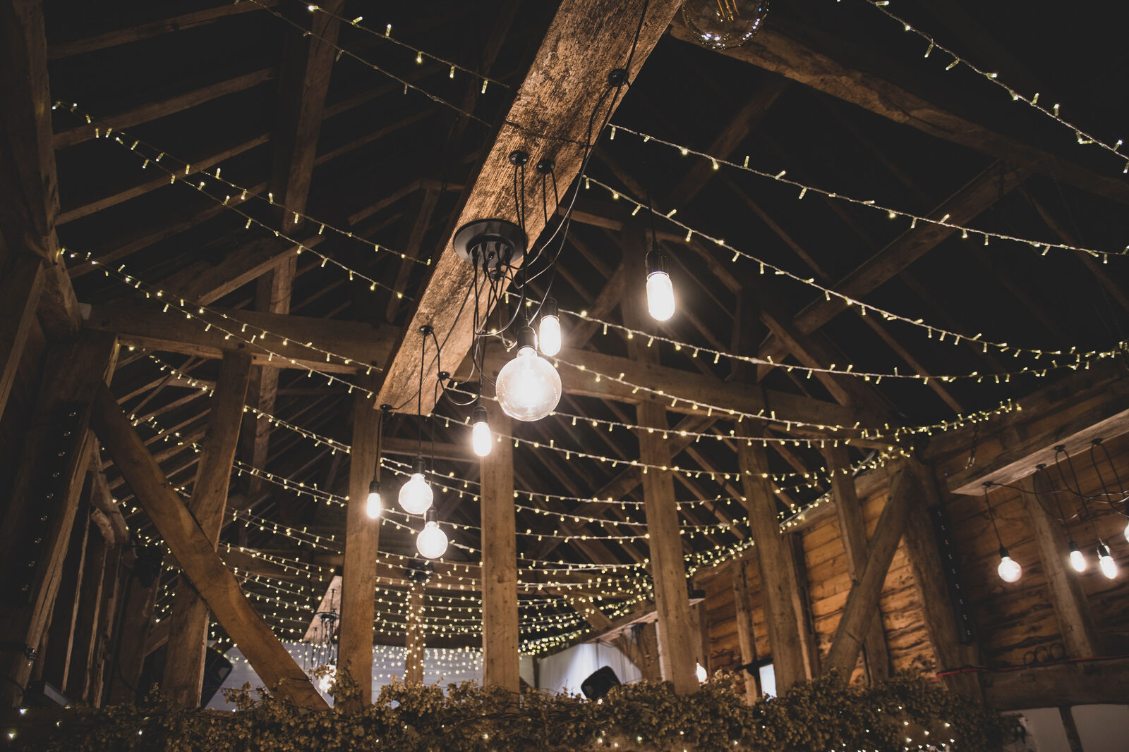 The oak rafters of the Apple Barn draped in thousands of fairy lights