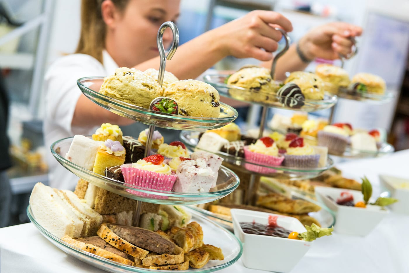 A tiered stand of sandwiches, scones and cakes being served at The BarnYard