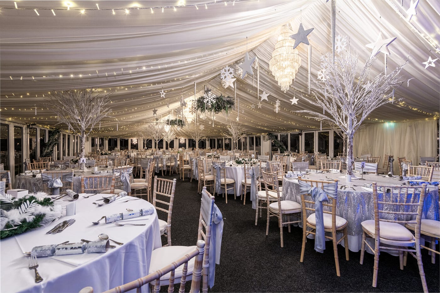 The pavilion at The BarnYard dressed for Christmas with silver trees, fairy lights and set tables