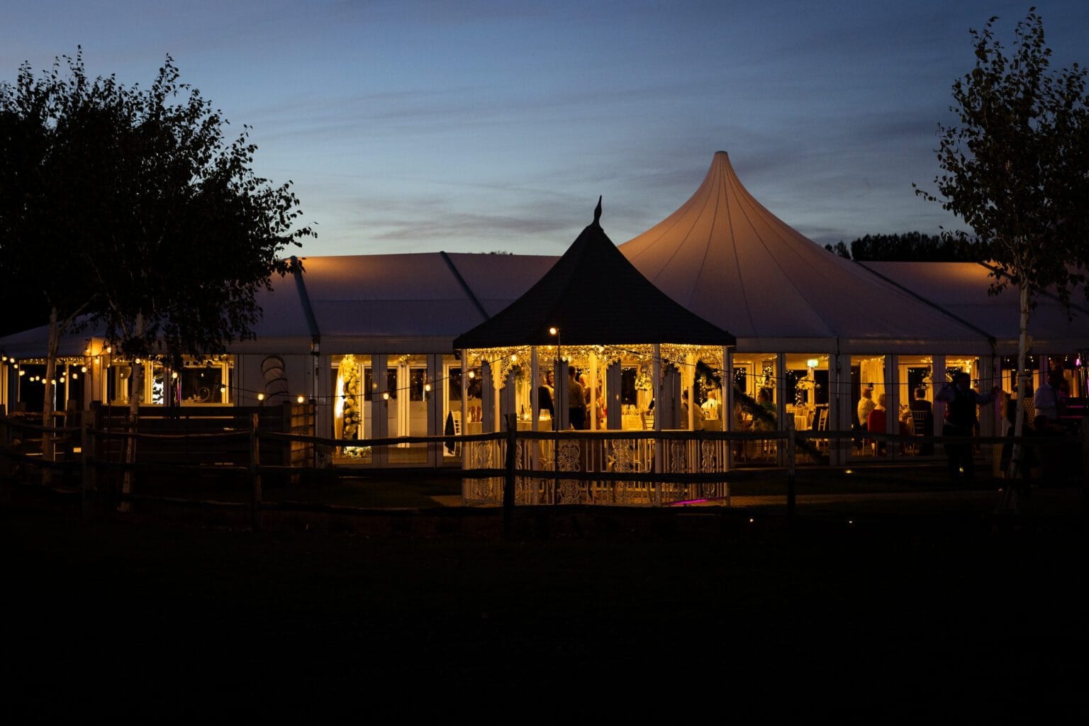 The Arboretum glass pavilion glowing with fairy lights at dusk