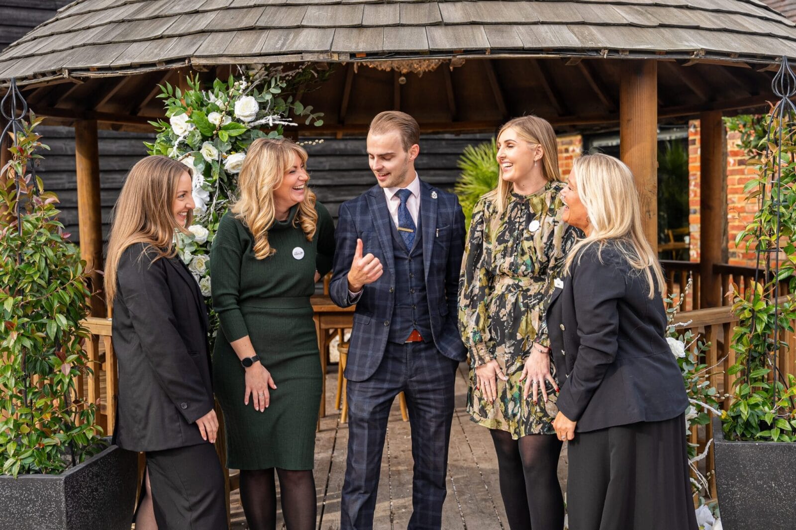 The BarnYard team laughing together by the gazebo at the venue in Kent