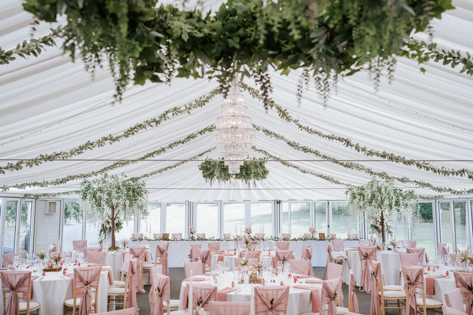 The Arboretum dressed for a wedding with hanging foliage, a crystal chandelier and blush styling