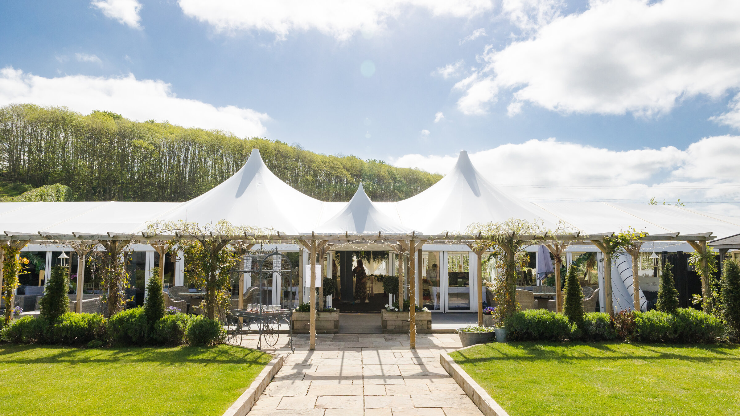 The Arboretum pavilion at The BarnYard in Kent, framed by pergola walkways and orchards