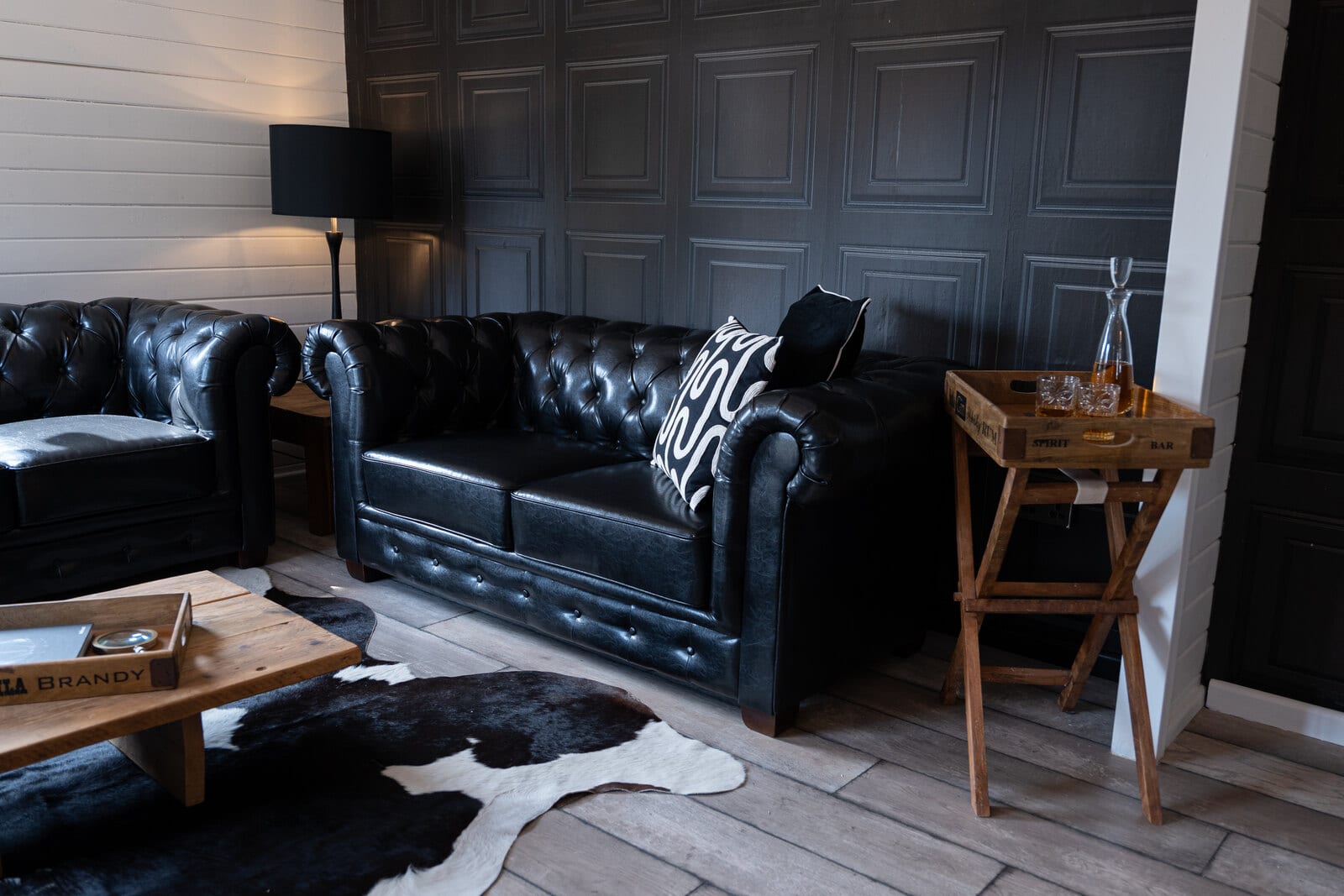 The Hyde Out suite at The BarnYard, a sleek modern lounge with full-length mirrors and a private patio