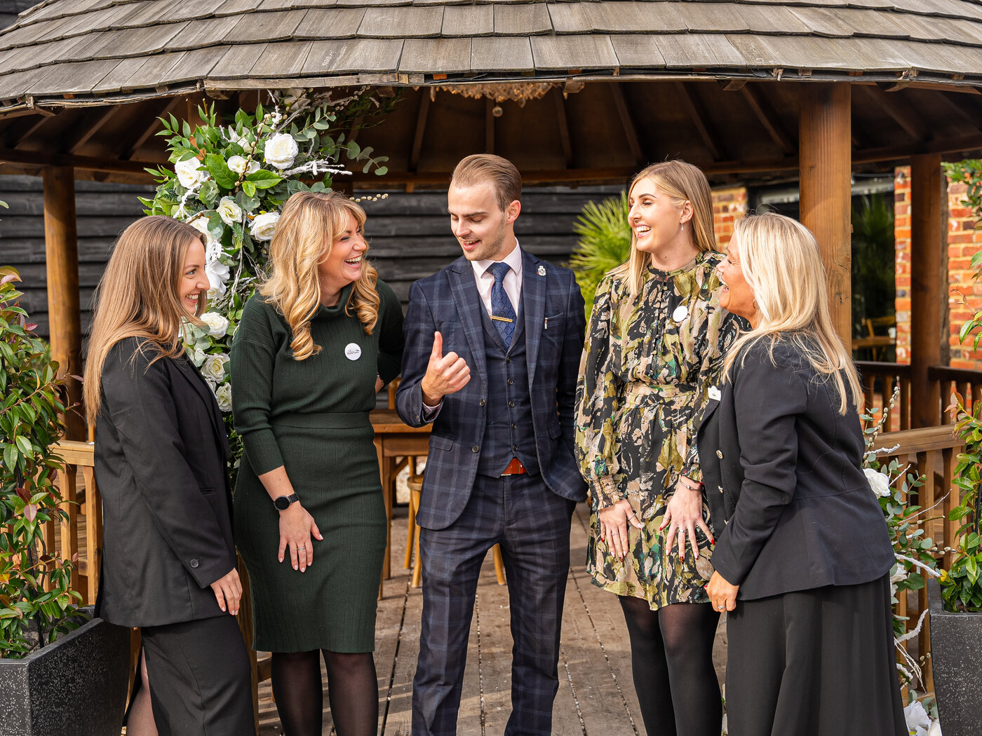 The BarnYard wedding team talking together beneath the Courtyard gazebo